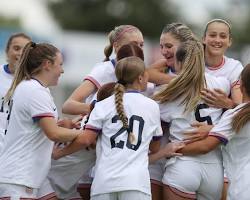 A professional soccer coach standing on the touchline analyzing the game.